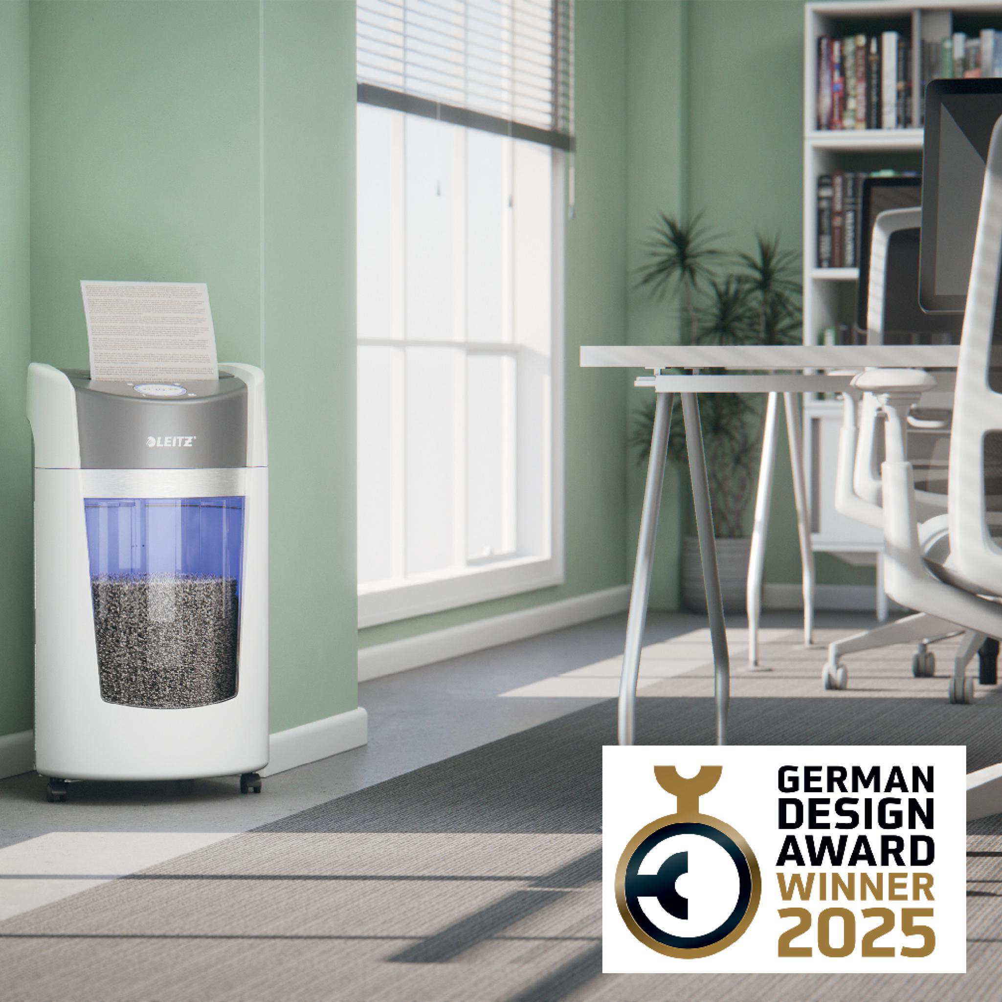 Ein Aktenvernichter mit einem Dokument, Büroumgebung mit Schreibtisch, Stuhl und einem Logo des German Design Award Winner 2025.
