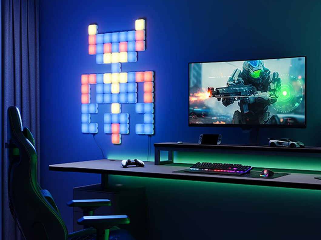 Una sala giochi con una luce a LED a forma di robot, un monitor di gioco e una scrivania con accessori di gioco.