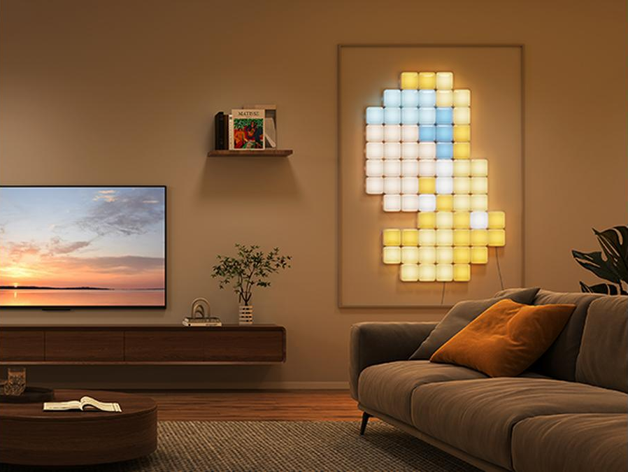 Soggiorno con arte murale di luci, TV, divano con cuscino arancione e tavolino.