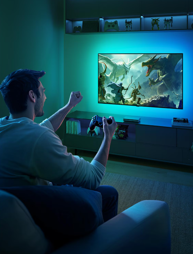 Uomo che gioca ai videogiochi, tiene un controller, guarda lo schermo eccitato. Lo schermo mostra una scena di battaglia di draghi.