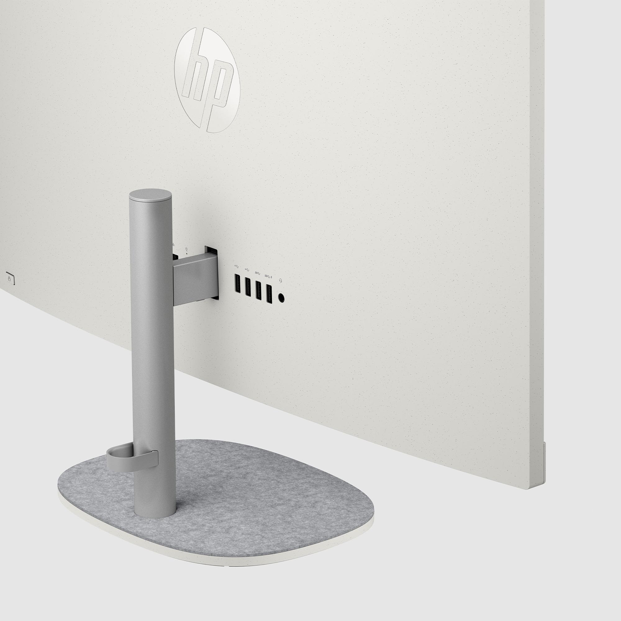 Rückseite eines weißen Monitors mit HP-Logo. Anschlüsse und Ständer sind sichtbar. Der Ständer hat eine graue Filzbasis.