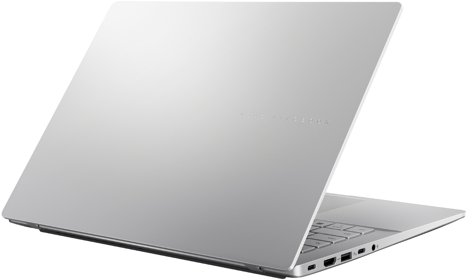 Un portátil plateado ASUS Vivobook está abierto, mostrando la parte trasera y el teclado. La superficie está limpia y el logotipo es visible.