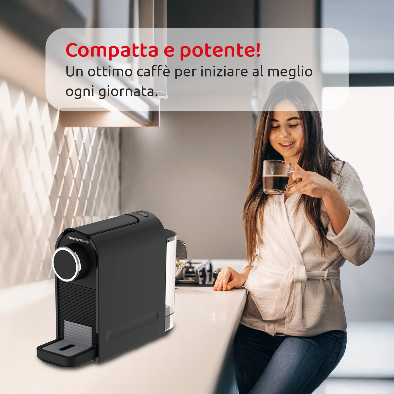 Una donna in accappatoio tiene in mano il caffè. Una macchina per caffè espresso nera è sul bancone. Il testo dice: 'Compatta e potente!'