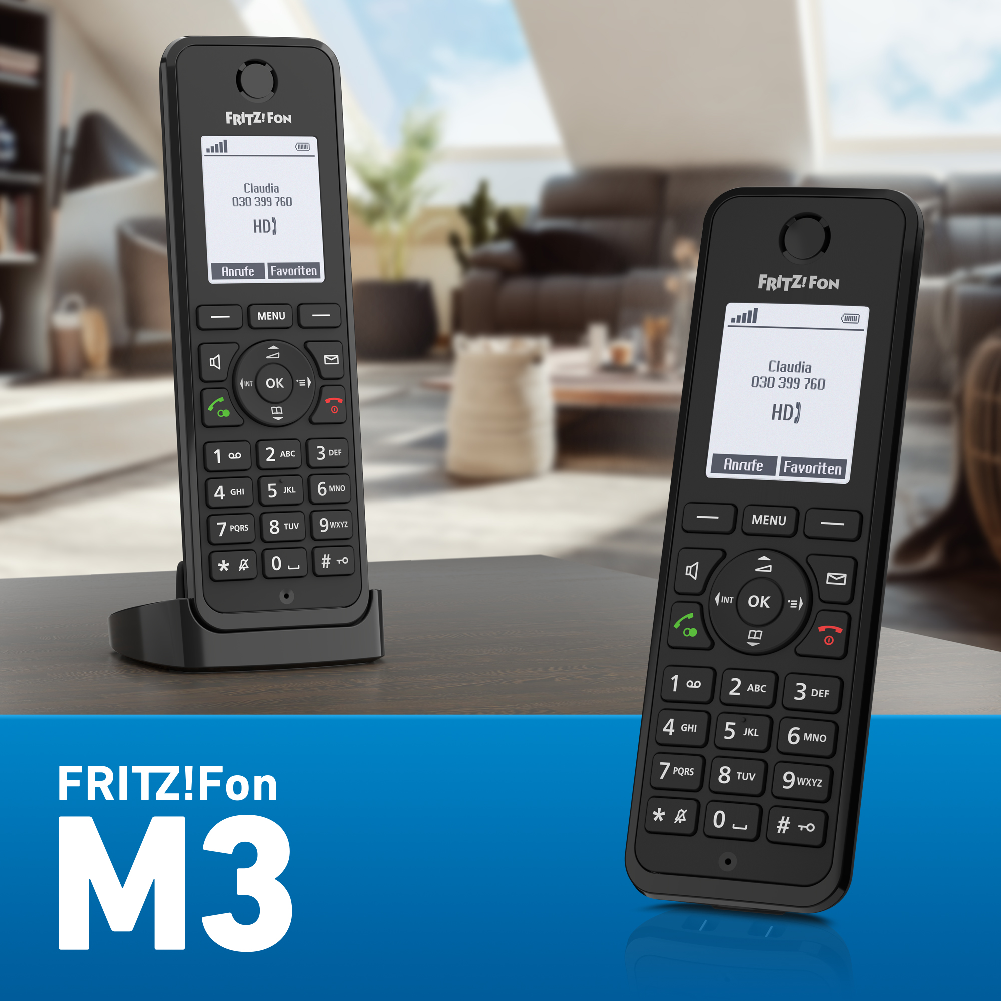 Zwei schwarze FRITZ!Fon M3 Telefone auf einem Holztisch. Eines in der Basis, das andere gehalten. Display zeigt Claudia, Telefonnummer.