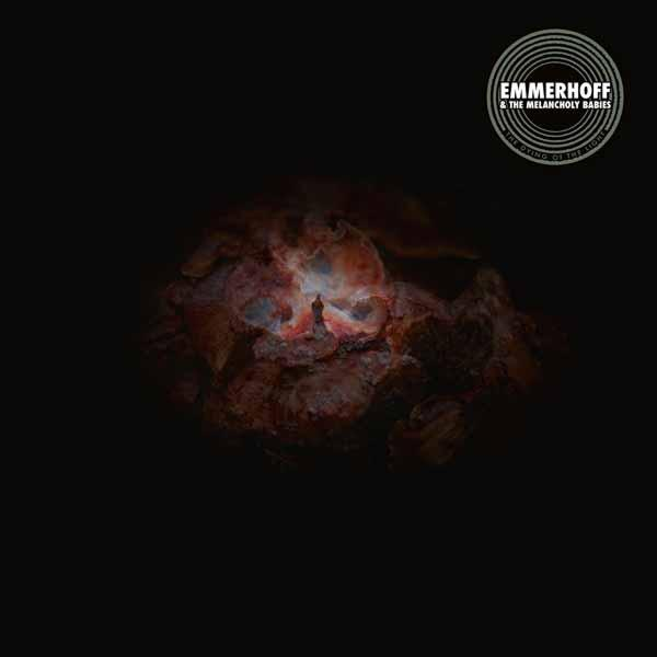Albumcover mit dunklem Hintergrund und einer zentralen, abstrakten, mehrfarbigen Form. Ein kreisförmiges Logo oben rechts lautet 'Emmerhoff'.