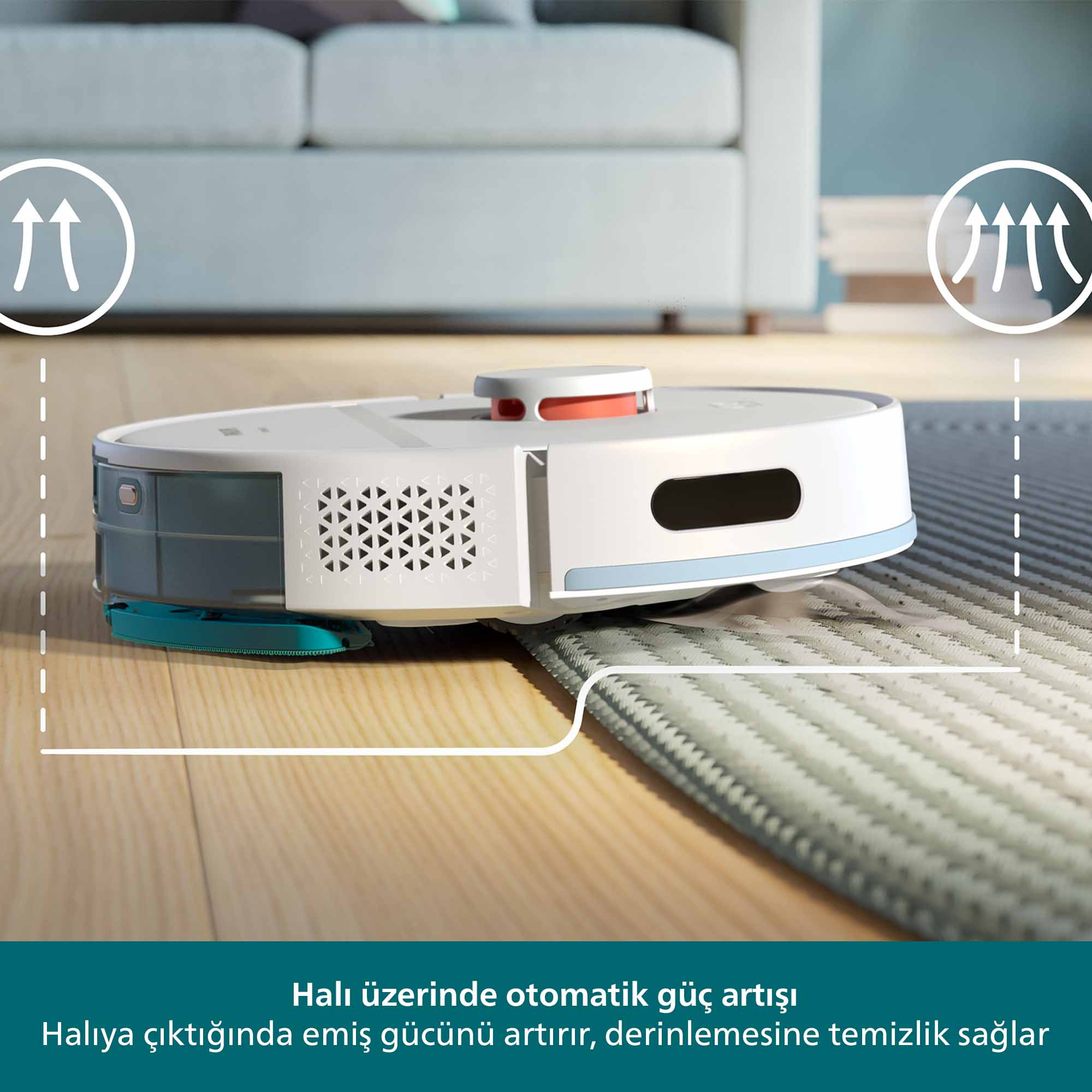 Halı üzerinde bir robot süpürge. Süpürge beyaz, gri ve mavidir. Açık mavi bir kanepenin önünde duruyor.
