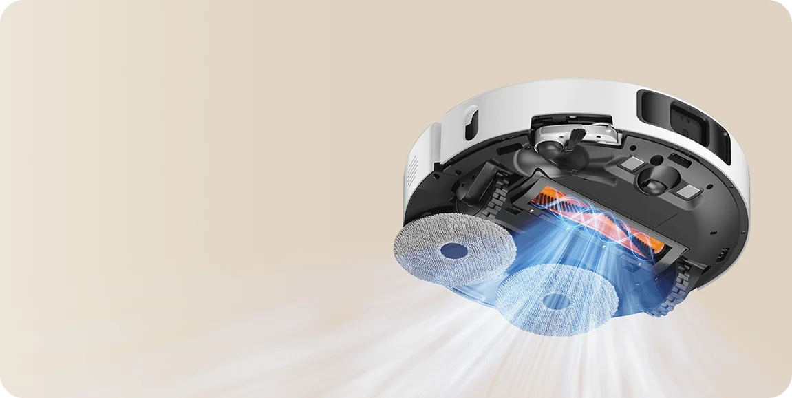 Biały robot odkurzający z dwoma nakładkami czyszczącymi, widok od dołu. Widoczna pomarańczowa szczotka i niebieski efekt świetlny.