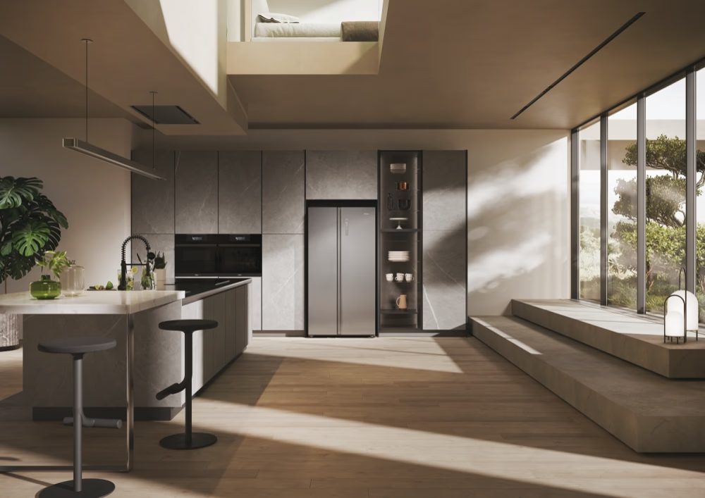 Cucina moderna con isola, sgabelli ed elettrodomestici ad incasso. Grandi finestre offrono una vista sul verde. Un letto a soppalco è visibile sopra.