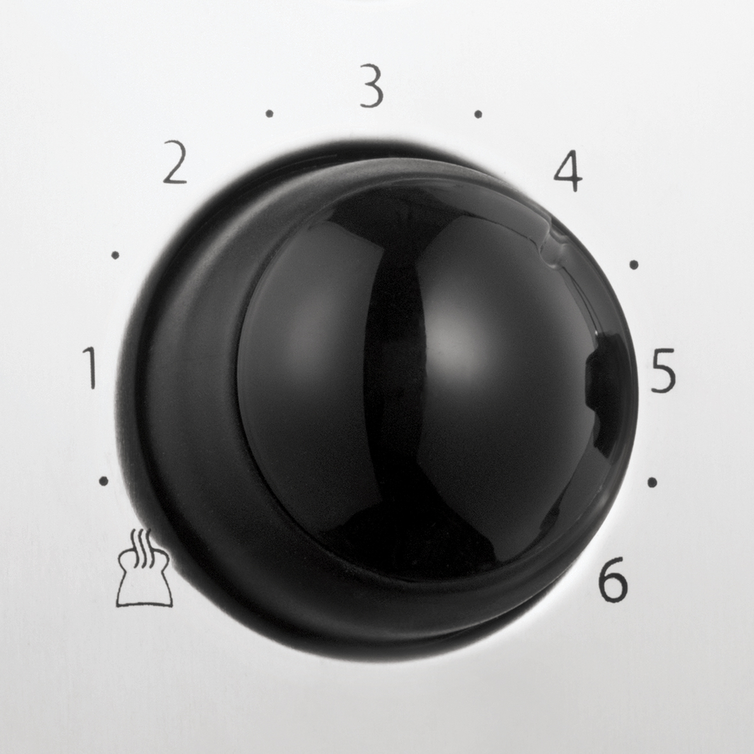 A close-up of a black knob on a white surface. Numbers 1-6 mark settings, a toast symbol is at the bottom.