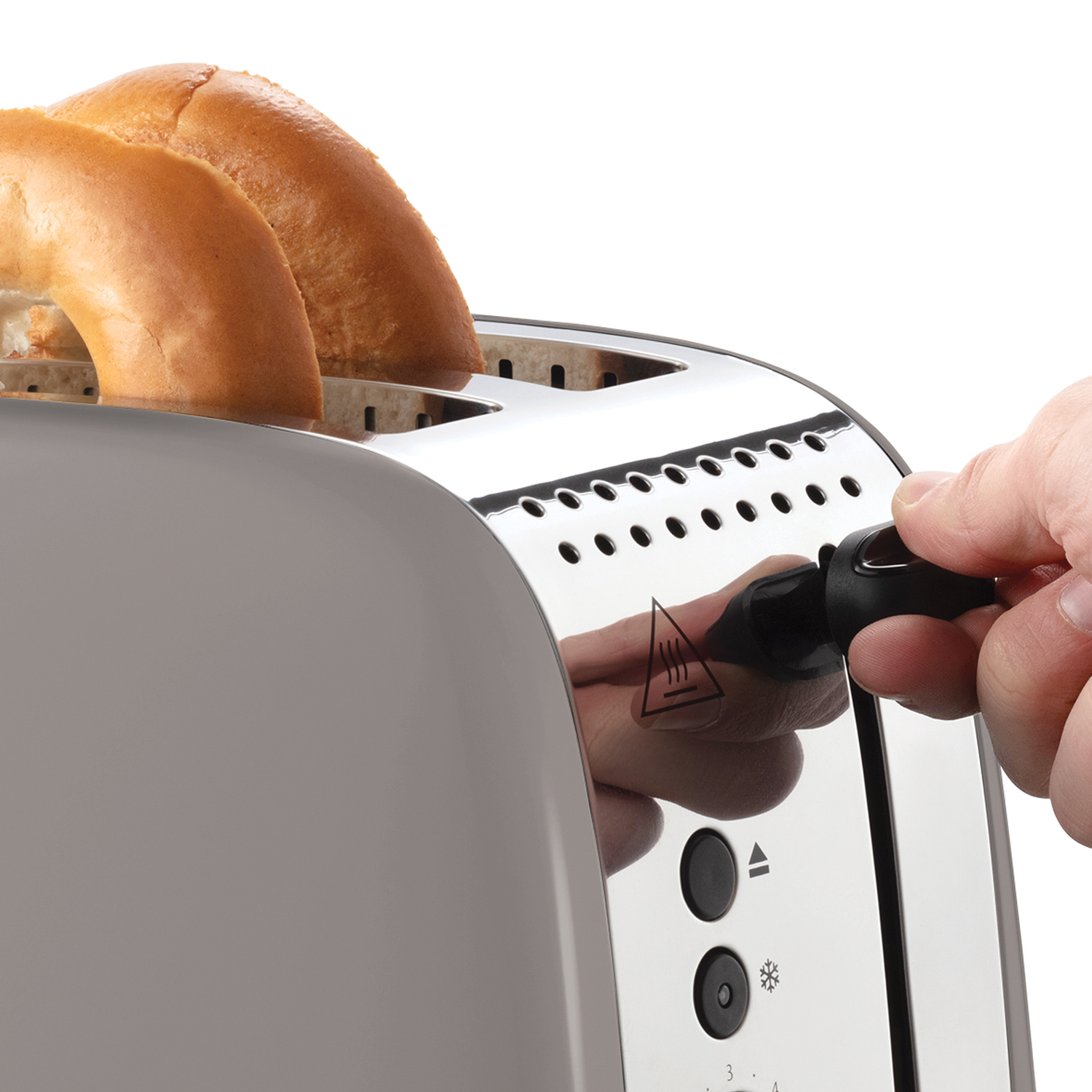 A hand is lowering a lever on a toaster with two bagels inside. The toaster is gray and silver, with a white background.