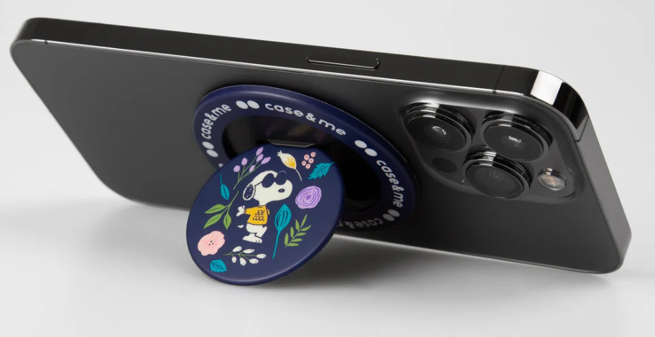Schwarzes iPhone mit einem Snoopy-Handygriff. Der Griff ist marineblau mit floralen Designs und Snoopy mit Sonnenbrille.