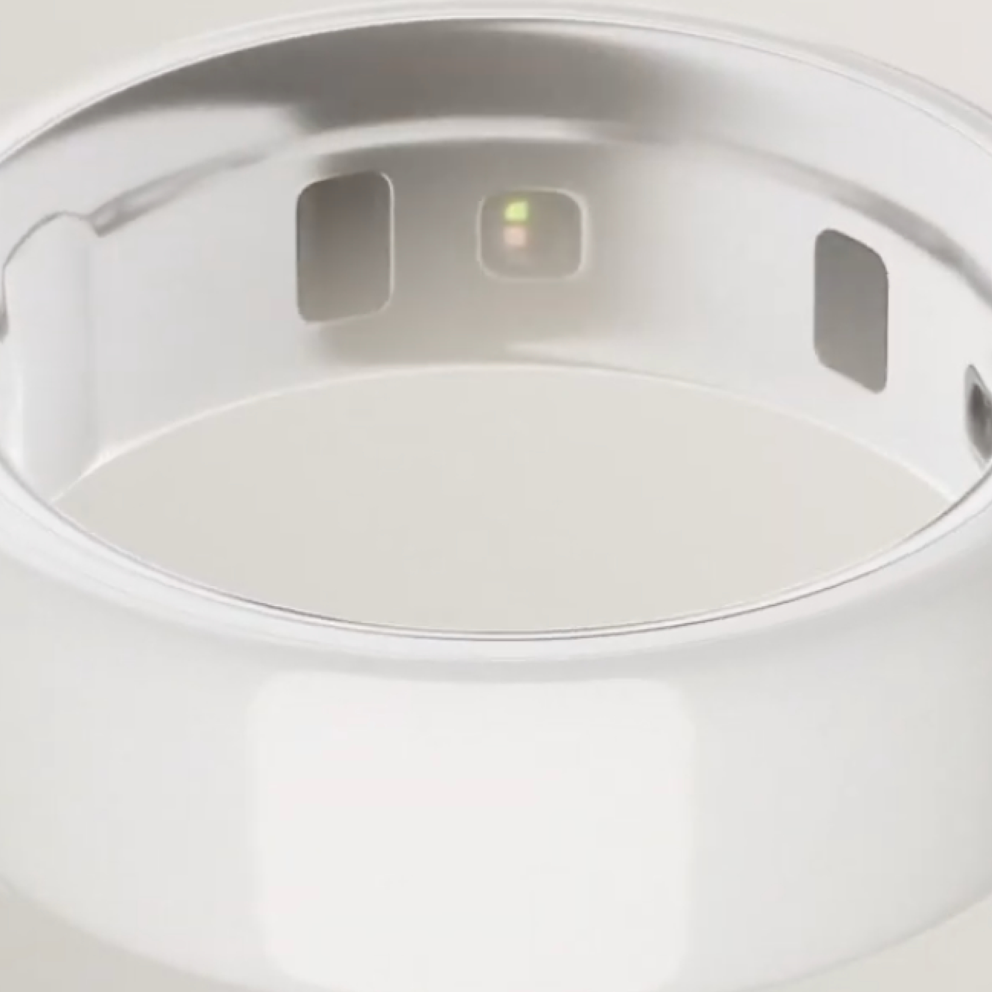 Nahaufnahme eines silbernen intelligenten Rings mit drei rechteckigen Öffnungen. Es hat einen kleinen, beleuchteten Bereich.