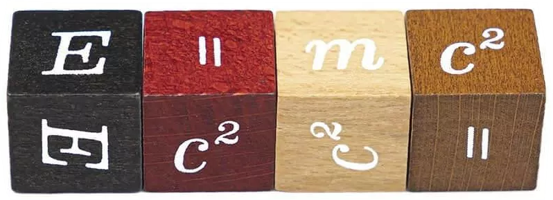 Négy fa tömb jeleníti meg az E=mc² képletet. A tömbök fekete, piros, világosbarna és sötétbarna, fehér felirattal.