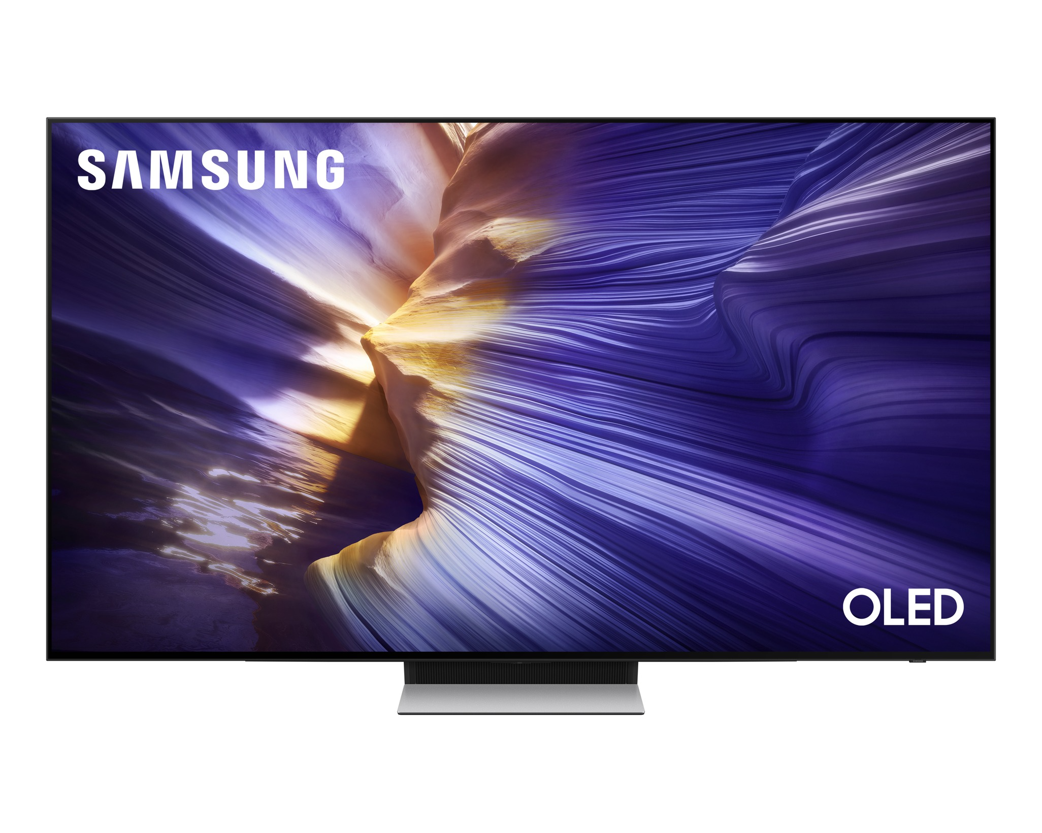 Egy Samsung OLED TV színes, absztrakt képet jelenít meg. A TV fekete kerettel és ezüst állvánnyal rendelkezik. A 'SAMSUNG' szó látható.