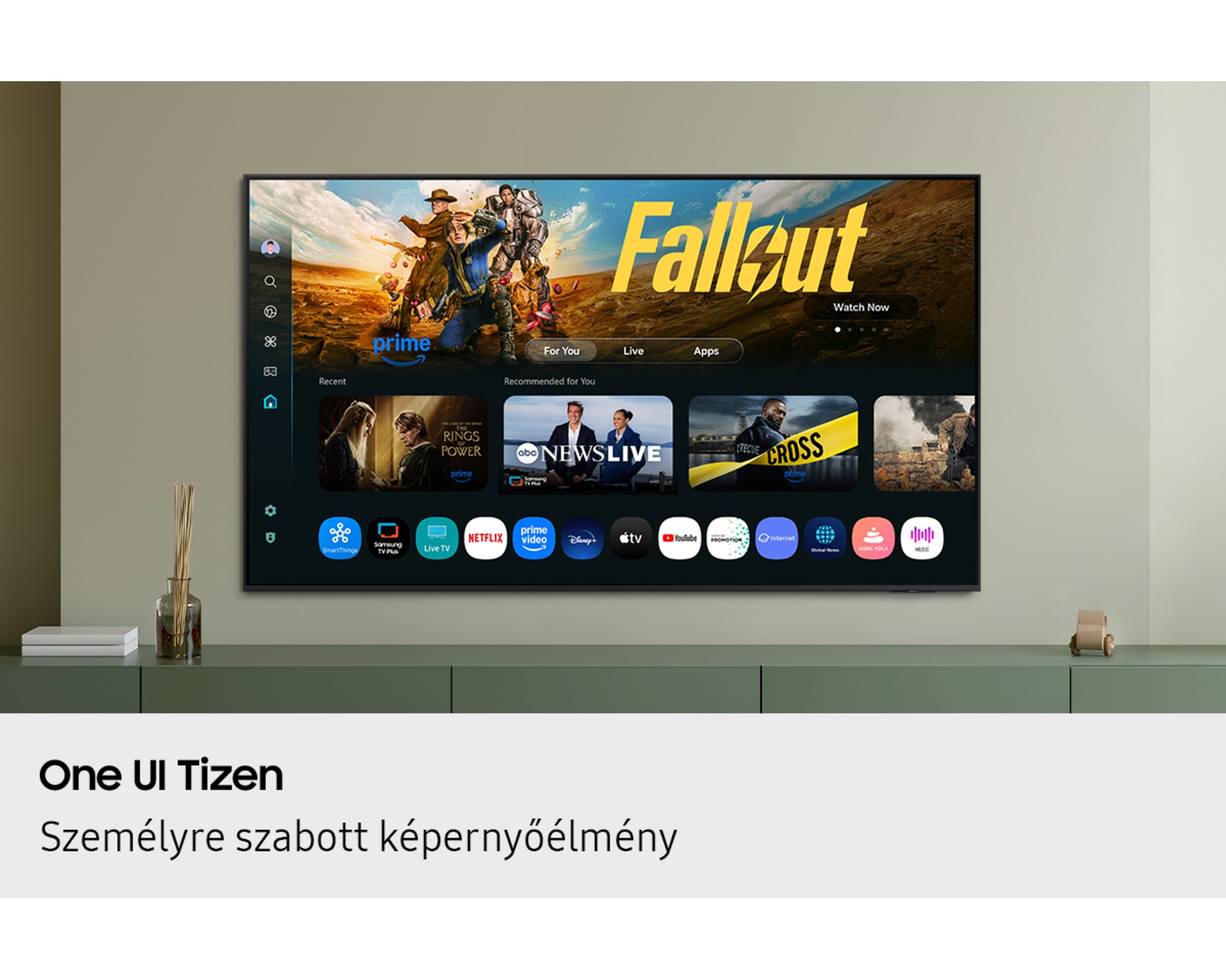 A TV-képernyőn a 'Fallout' című műsor látható a Prime Videóról. Alatta alkalmazásikonok vannak. A TV egy zöld szekrényen van.