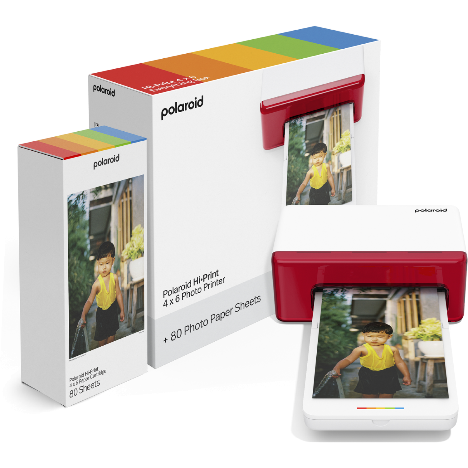 A Polaroid Hi-Print photo printer with a photo of a child. Boxes of paper and cartridges are also present.