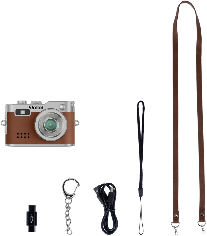 Eine braune und silberne Rollei-Kamera mit Zubehör: ein Gurt, eine Handschlaufe, ein Schlüsselanhänger, ein USB-Kabel und ein Speicherkartenleser.