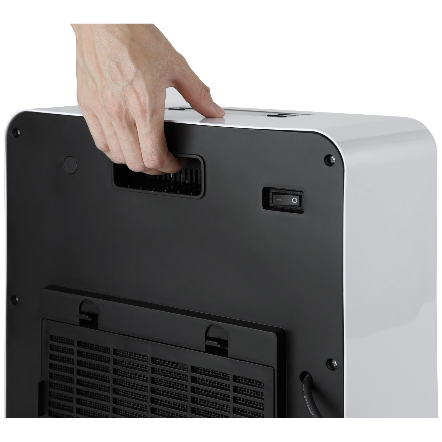 Een hand raakt een wit en zwart apparaat aan. Het apparaat heeft een schakelaar en een ventilatierooster. De achtergrond is wit.