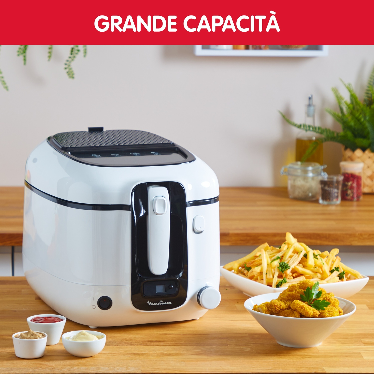 Una friggitrice bianca con parte superiore e pannello frontale neri è su un bancone di legno. Due ciotole di cibo e tre piccole ciotole di salsa sono accanto.
