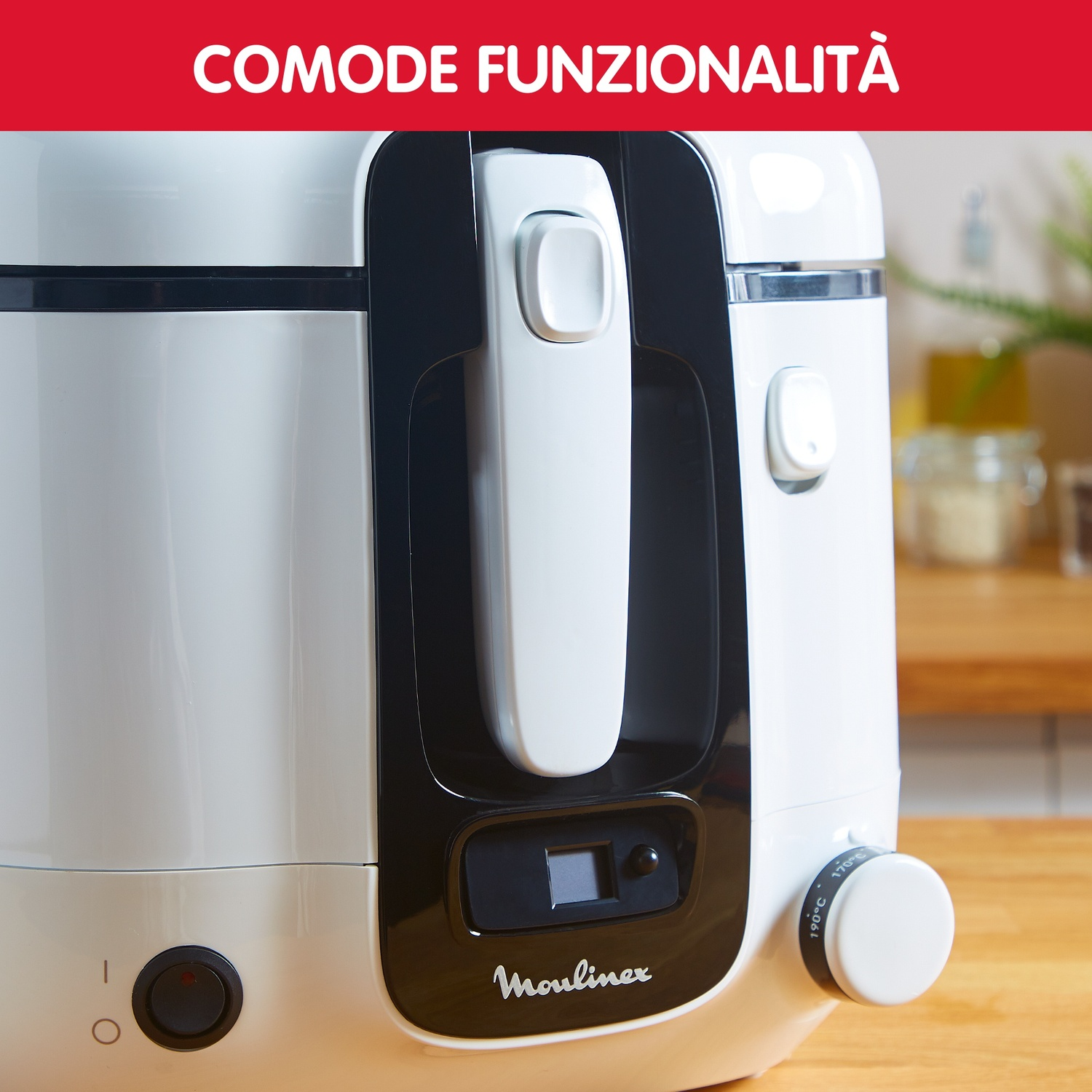 Primo piano di un elettrodomestico Moulinex bianco con dettagli neri. Sono visibili una maniglia, un quadrante e un pulsante di accensione. Lo sfondo è sfocato.