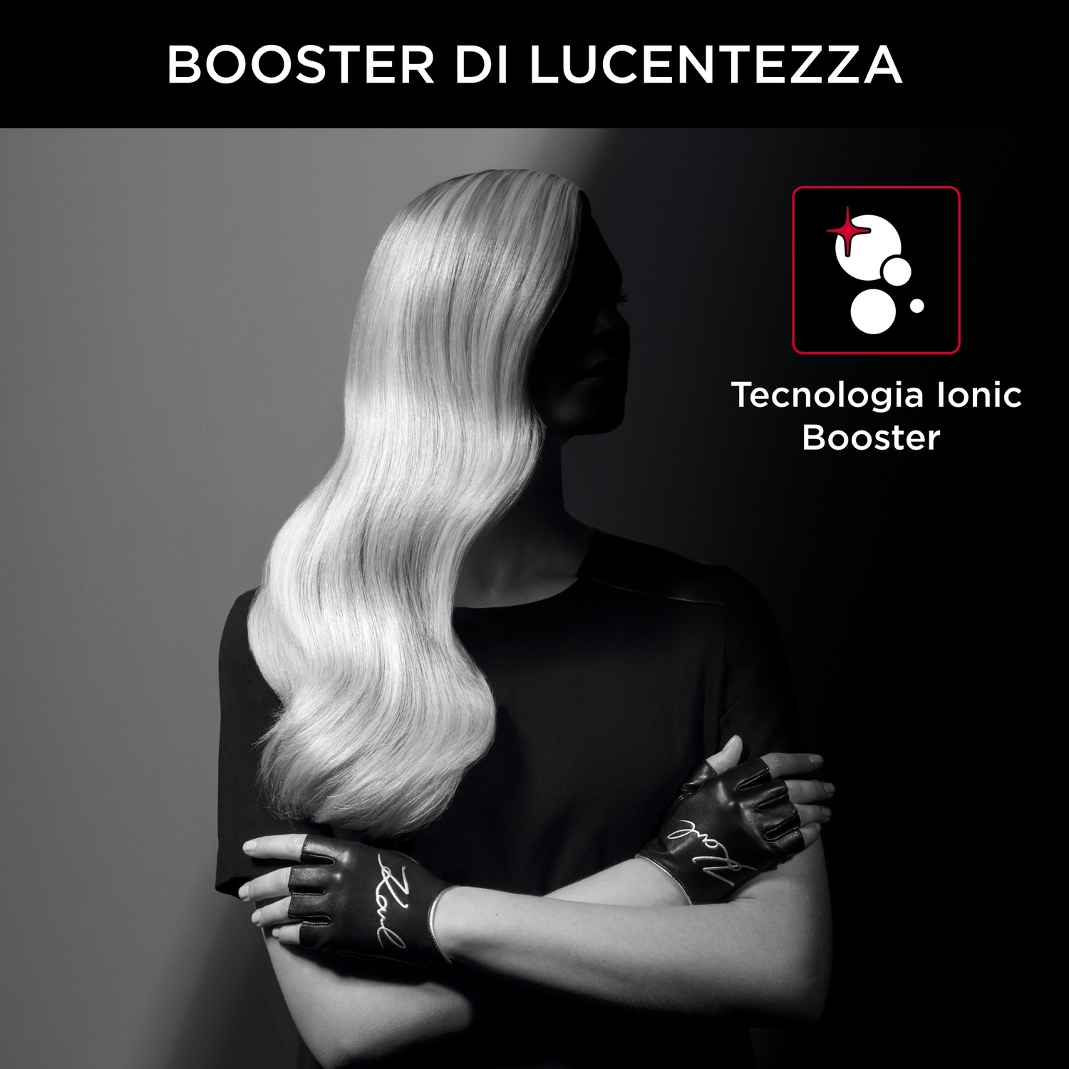 Donna con lunghi capelli biondi ondulati, guanti neri e top nero. Testo: 'BOOSTER DI LUCENTEZZA' e 'Tecnologia Ionic Booster'.
