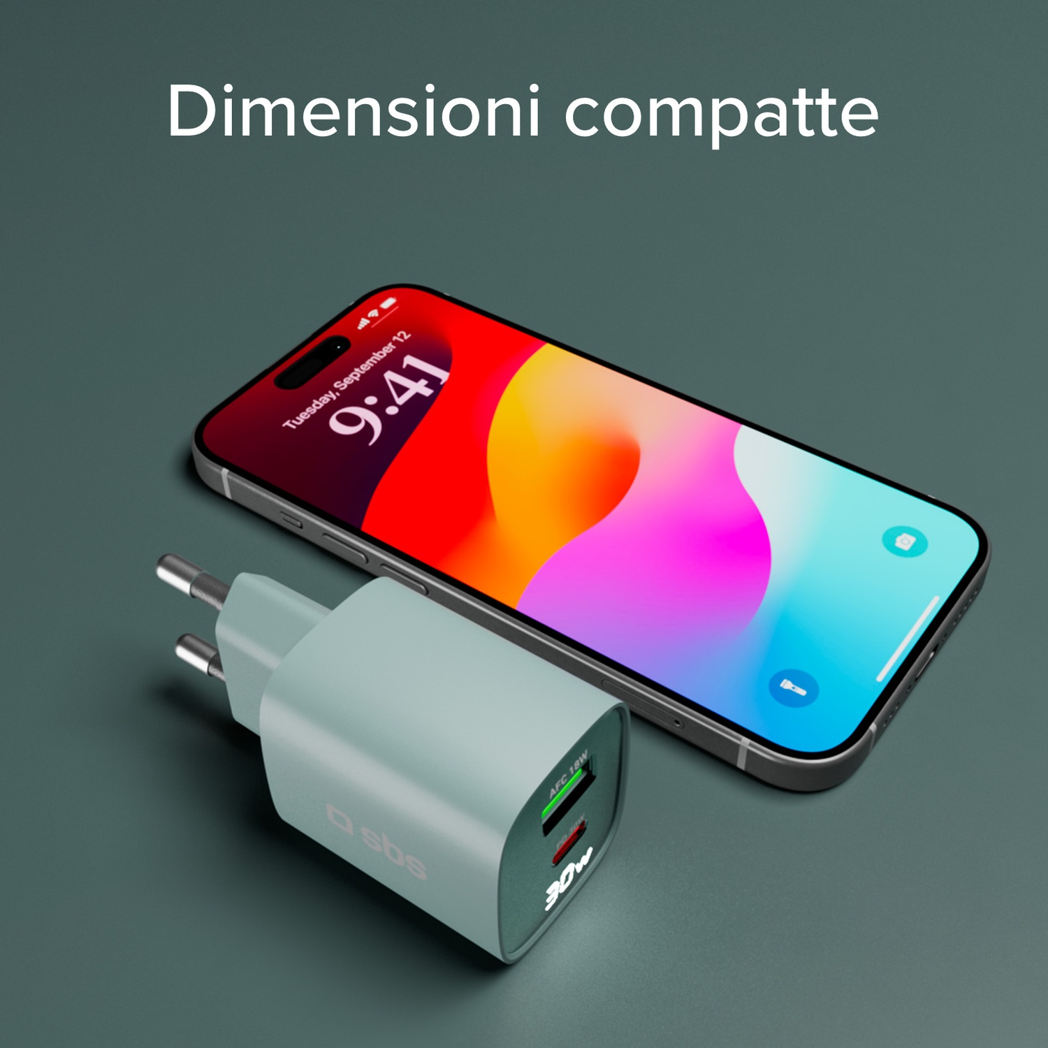 Uno smartphone accanto a un caricabatterie verde acqua, entrambi su una superficie verde acqua. Il telefono mostra uno sfondo colorato.