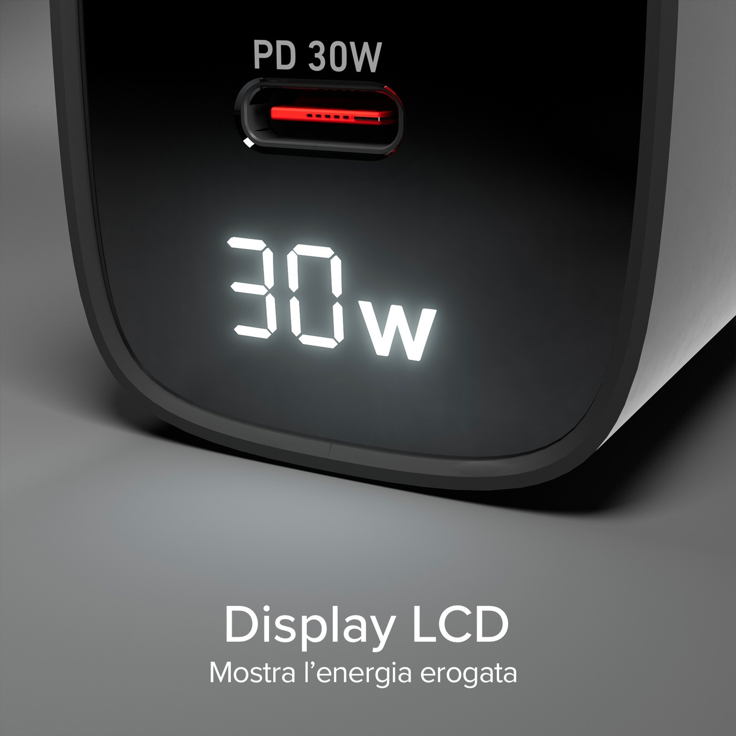 Primo piano di un caricabatterie nero che mostra '30W' su uno schermo digitale. Sopra c'è 'PD 30W'. Lo schermo è su uno sfondo grigio.