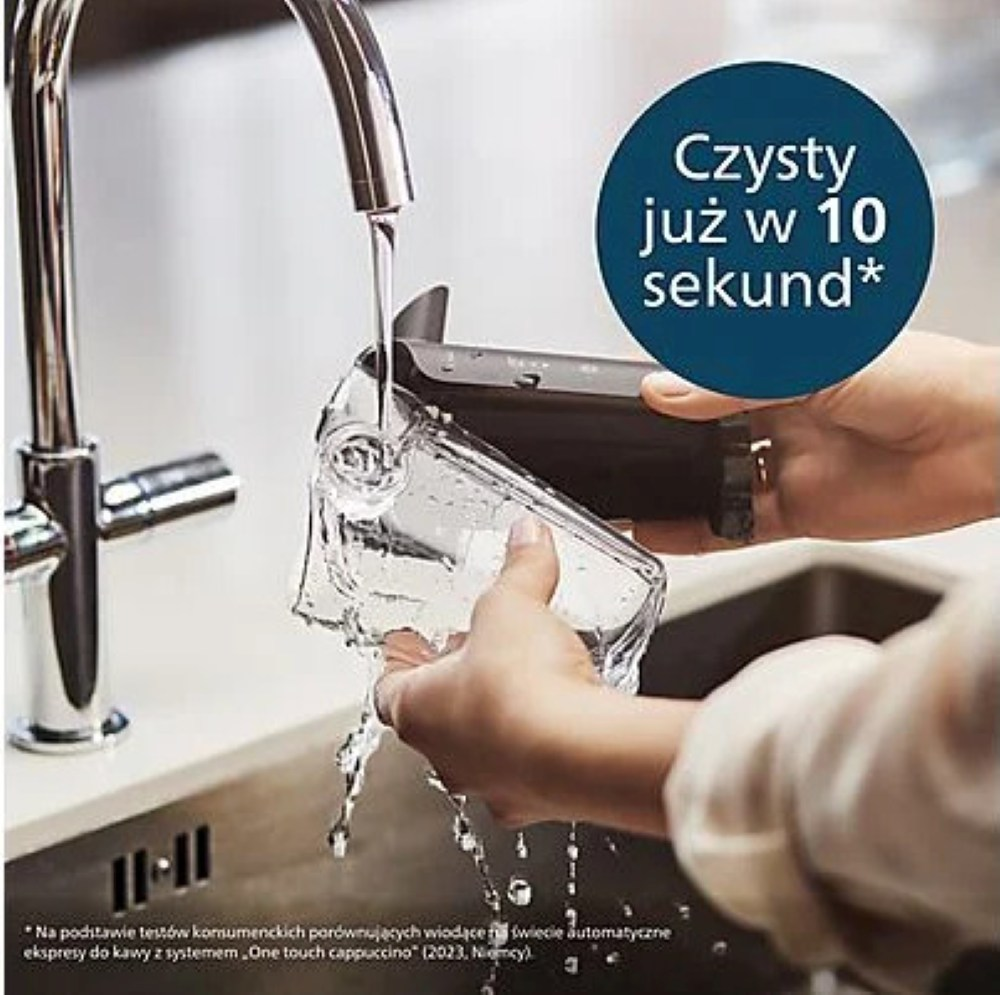 Osoba płucze przezroczysty element ekspresu do kawy pod kranem. Woda wypływa, ciemny element trzymany jest w rękach.