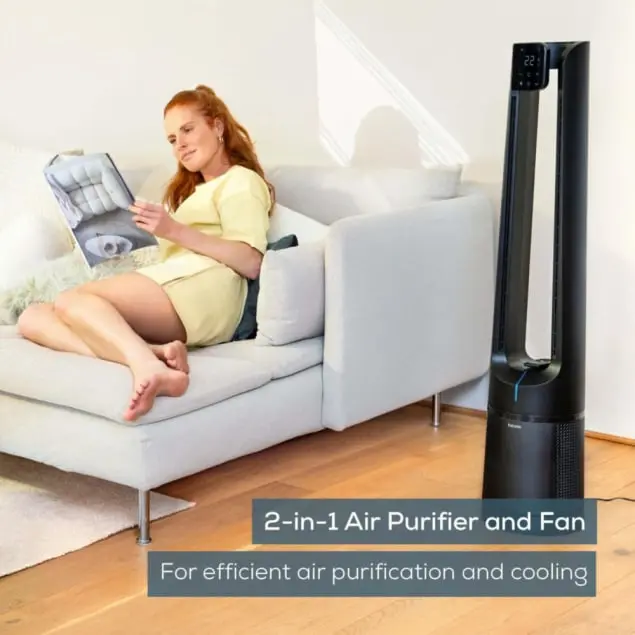 Femme rousse lisant sur un canapé, un ventilateur purificateur d'air noir est à côté d'elle. Texte en bas : "Purificateur d'air et ventilateur 2 en 1".