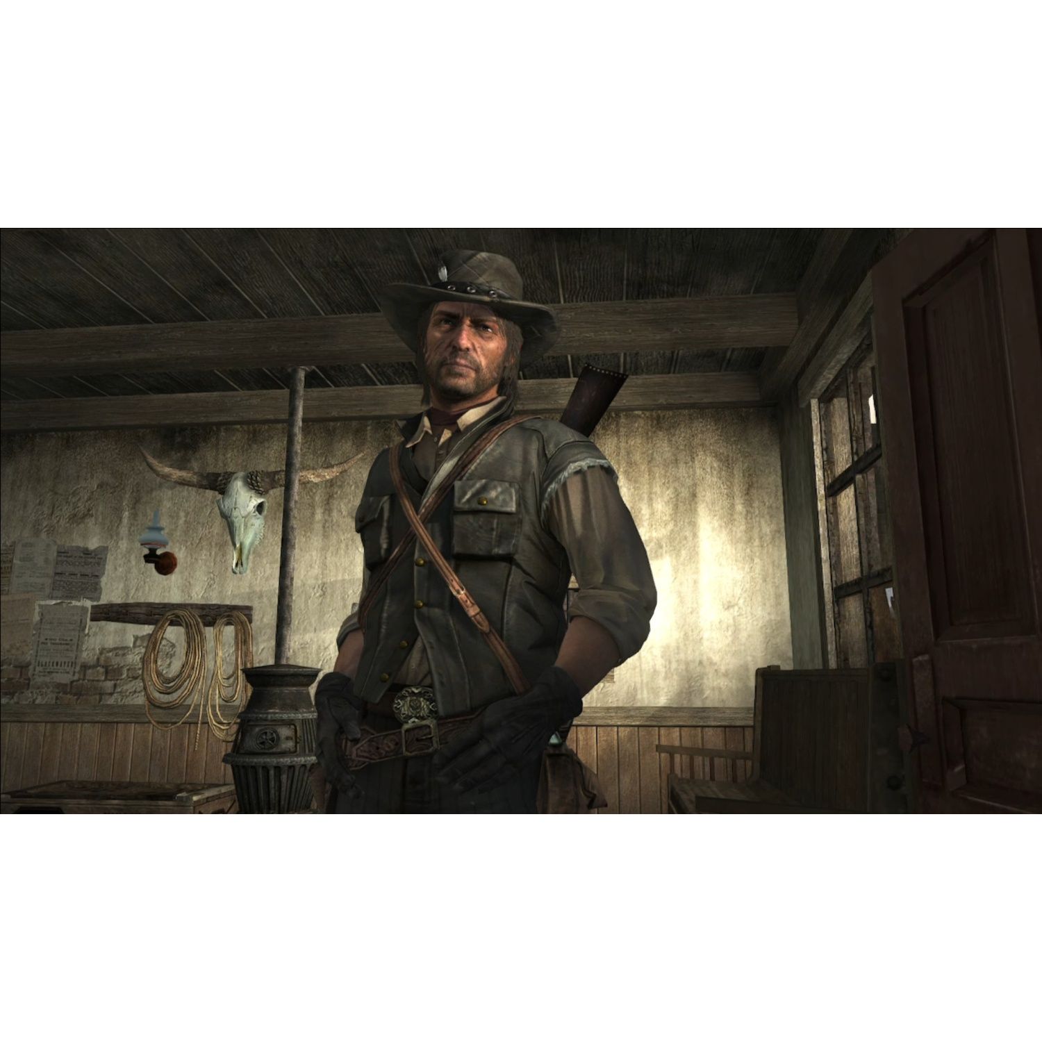 Un uomo con un cappello da cowboy è in un saloon. Un teschio di toro è appeso al muro. L'uomo indossa un gilet e un fucile.