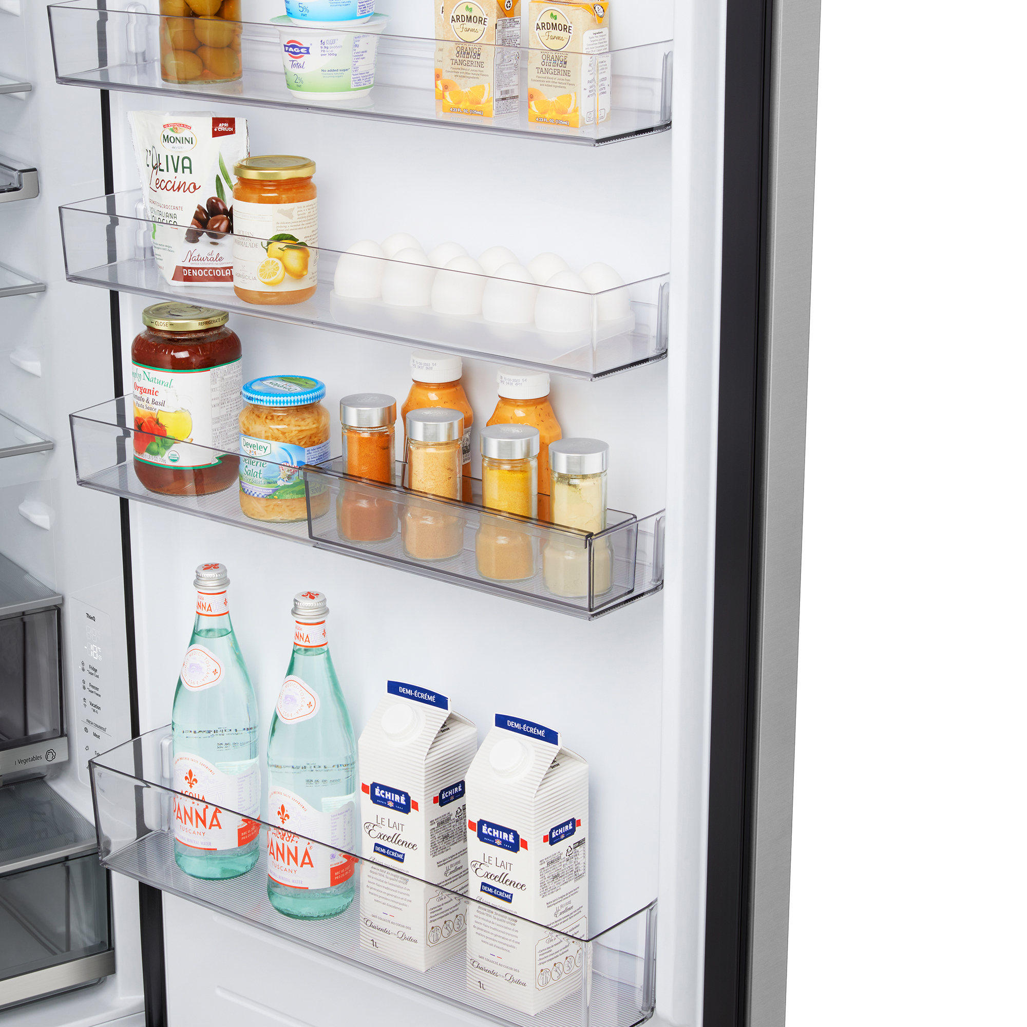 Interior de un refrigerador con varios alimentos en estantes, incluyendo frascos, botellas y cartones. Botellas de agua en el estante inferior.