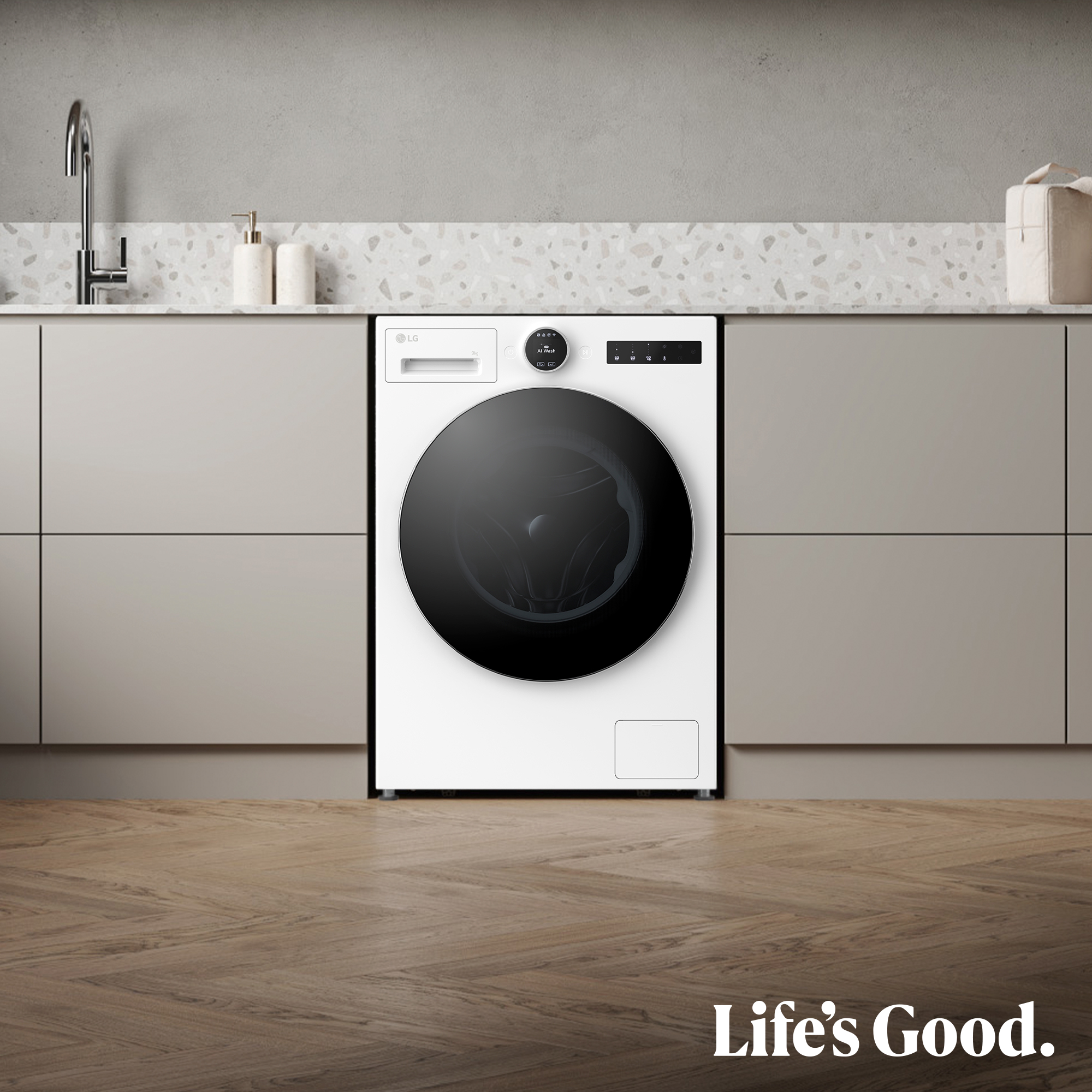 Una lavadora LG blanca con puerta negra en una cocina. El suelo es de madera y el fondo es una pared.