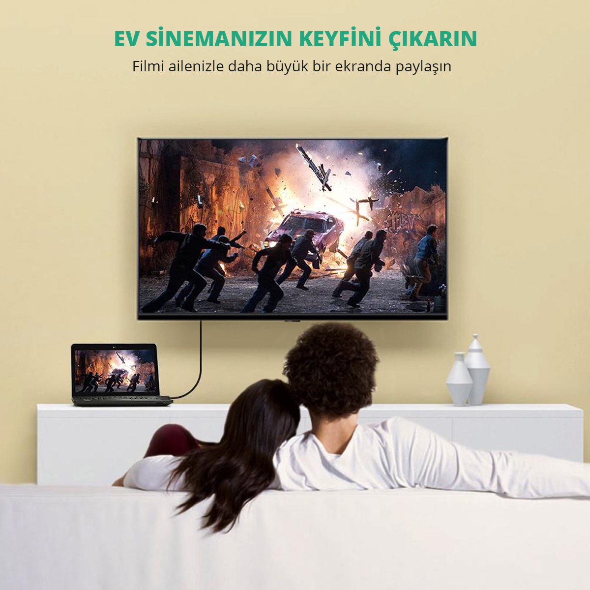 Bir çift TV'de film izliyor. Bir dizüstü bilgisayar bağlı. TV'de aksiyon sahnesi gösteriliyor. Metin: 'Ev sinemanızın keyfini çıkarın'.