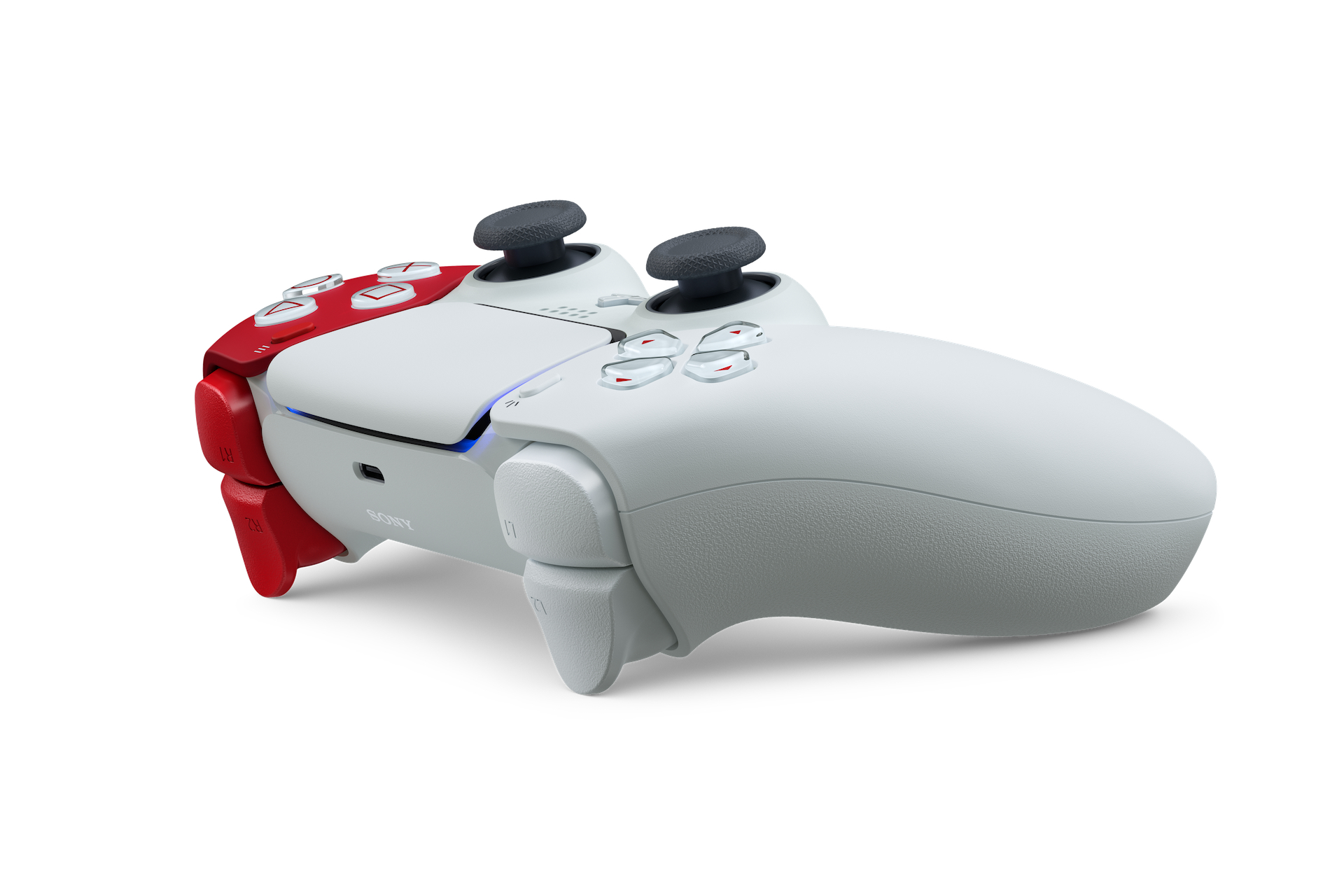 Ein weiß-roter PS5-Controller liegt auf einer weißen Oberfläche. Er hat schwarze Thumbsticks und graue Knöpfe. Das Sony-Logo ist sichtbar.