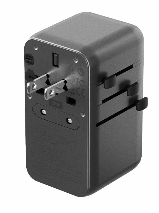 Czarny adapter podróżny z bolcami, suwakami i portami. Ma prostokątny kształt i wtyczkę.