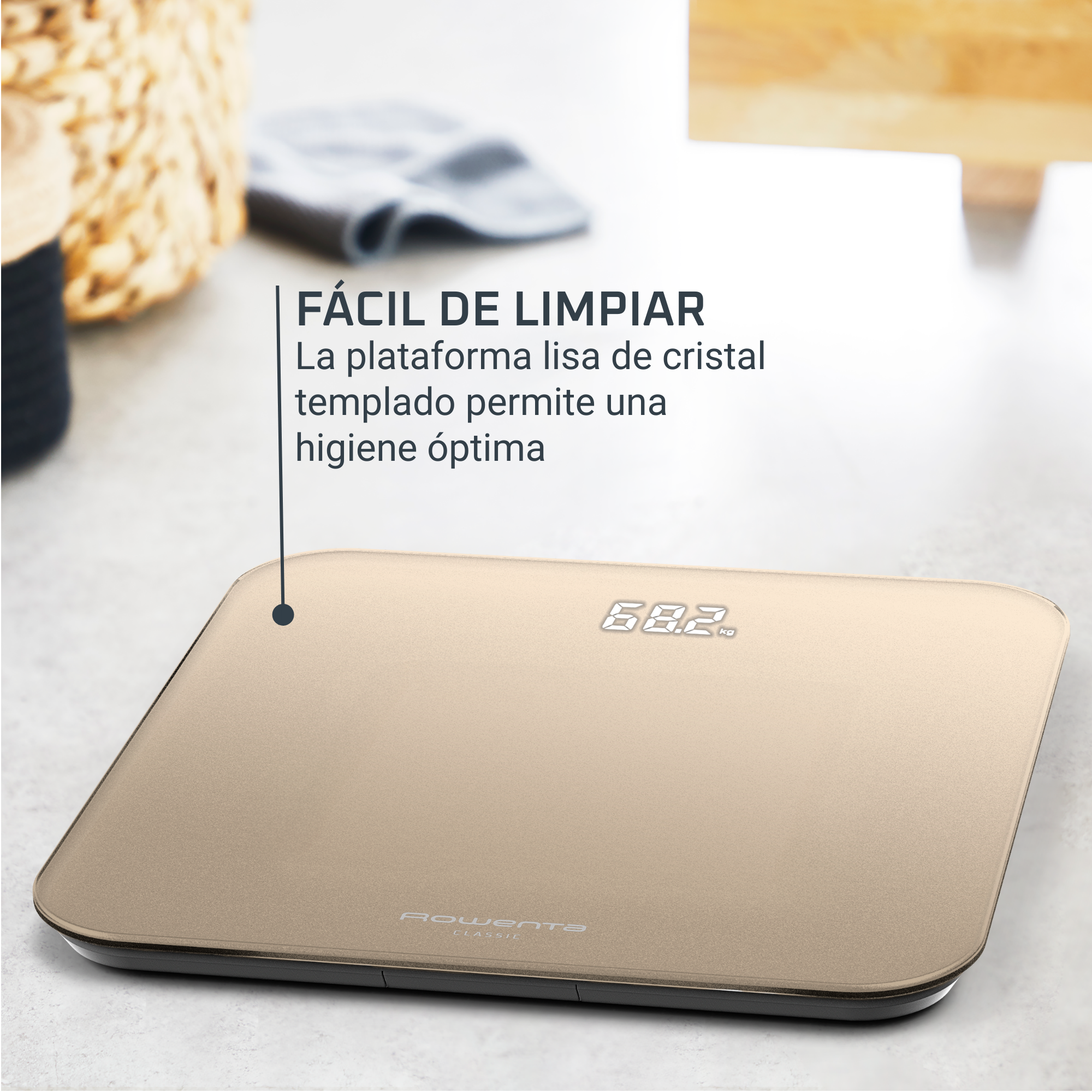 Báscula digital dorada con pantalla de peso de 68,2 kg. Texto en español. Fondo: cesta de mimbre y tela borrosas.