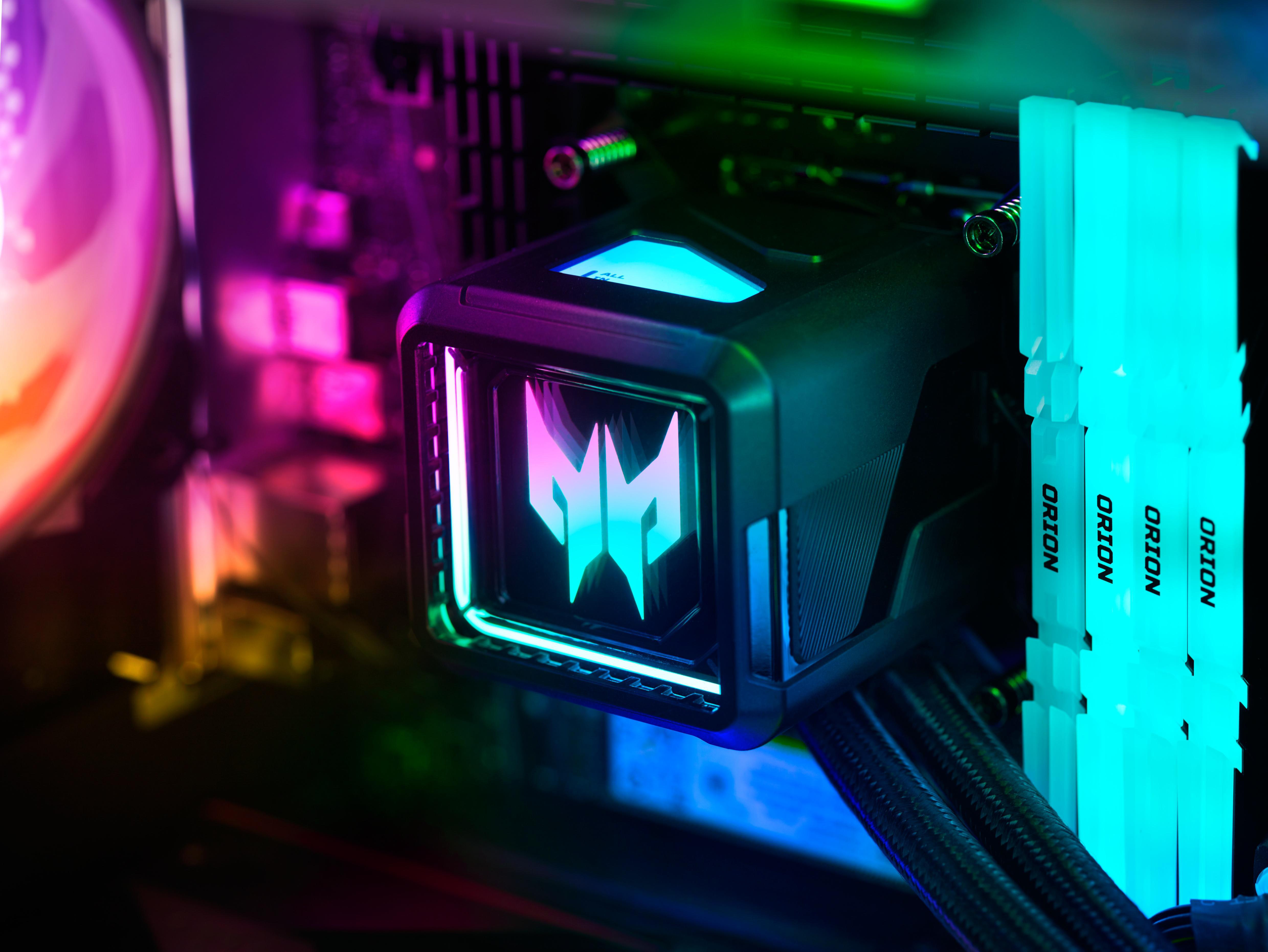 Nahaufnahme von Computerkomponenten mit RGB-Beleuchtung. Fokus auf Wasserkühler und RAM-Riegel. Farben sind Teal, Lila und Blau.