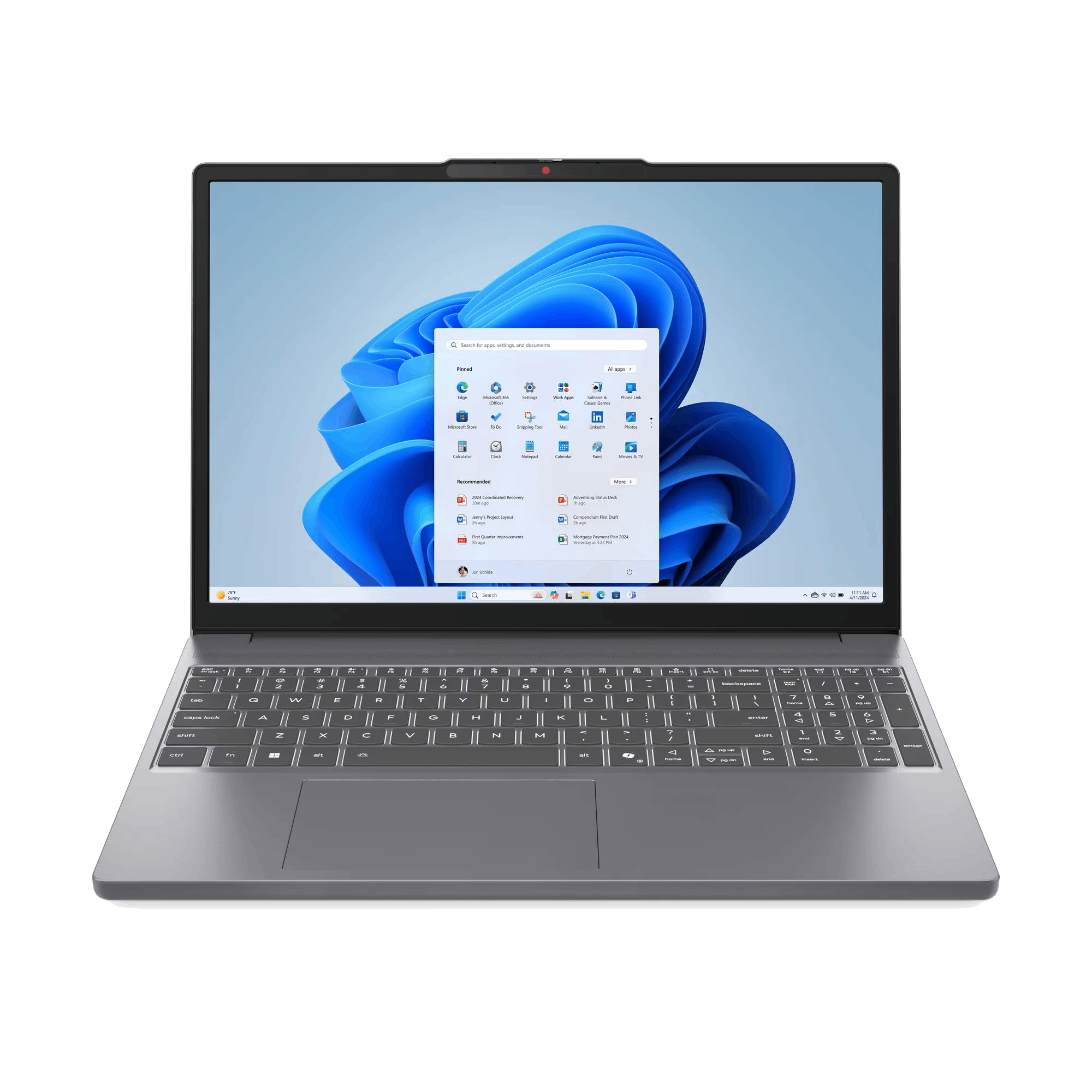 Un portátil muestra la interfaz de Windows 11. El teclado es visible debajo de la pantalla, contra un fondo negro.