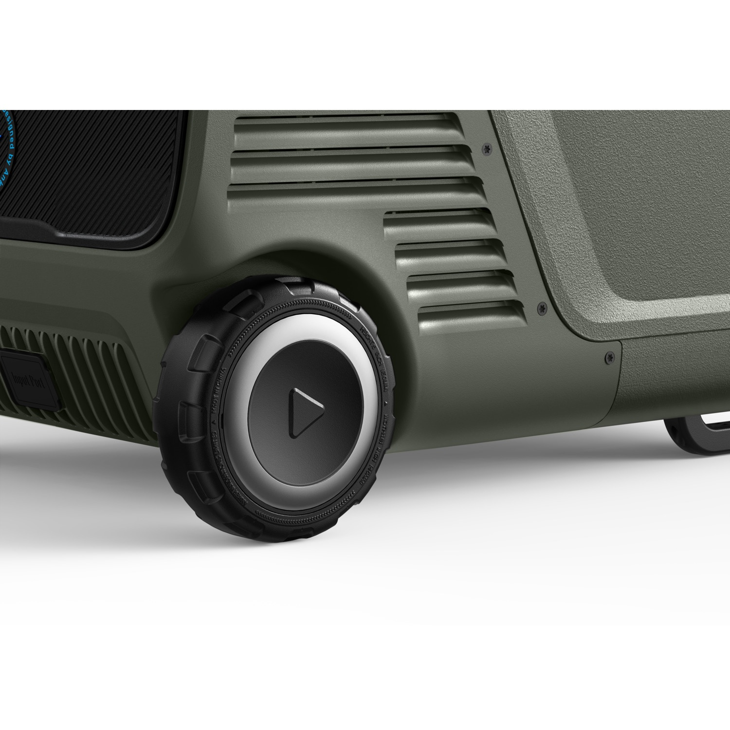 Close-up of a green speaker on wheels. The wheel has a silver center with a black triangle. Part of the speaker is visible.