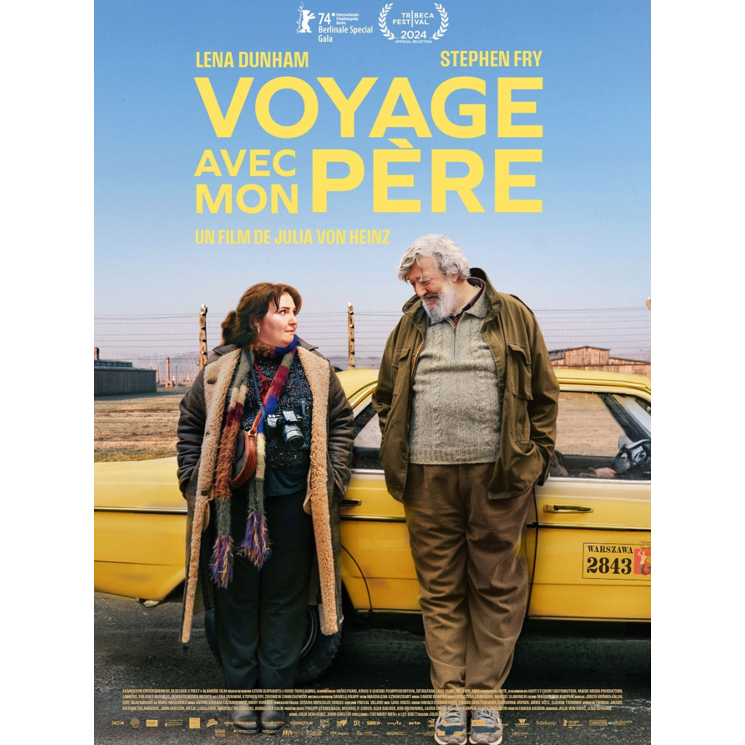 Filmposter met twee mensen, een vrouw en een man, naast een gele auto. De titel is 'Voyage Avec Mon Père'.
