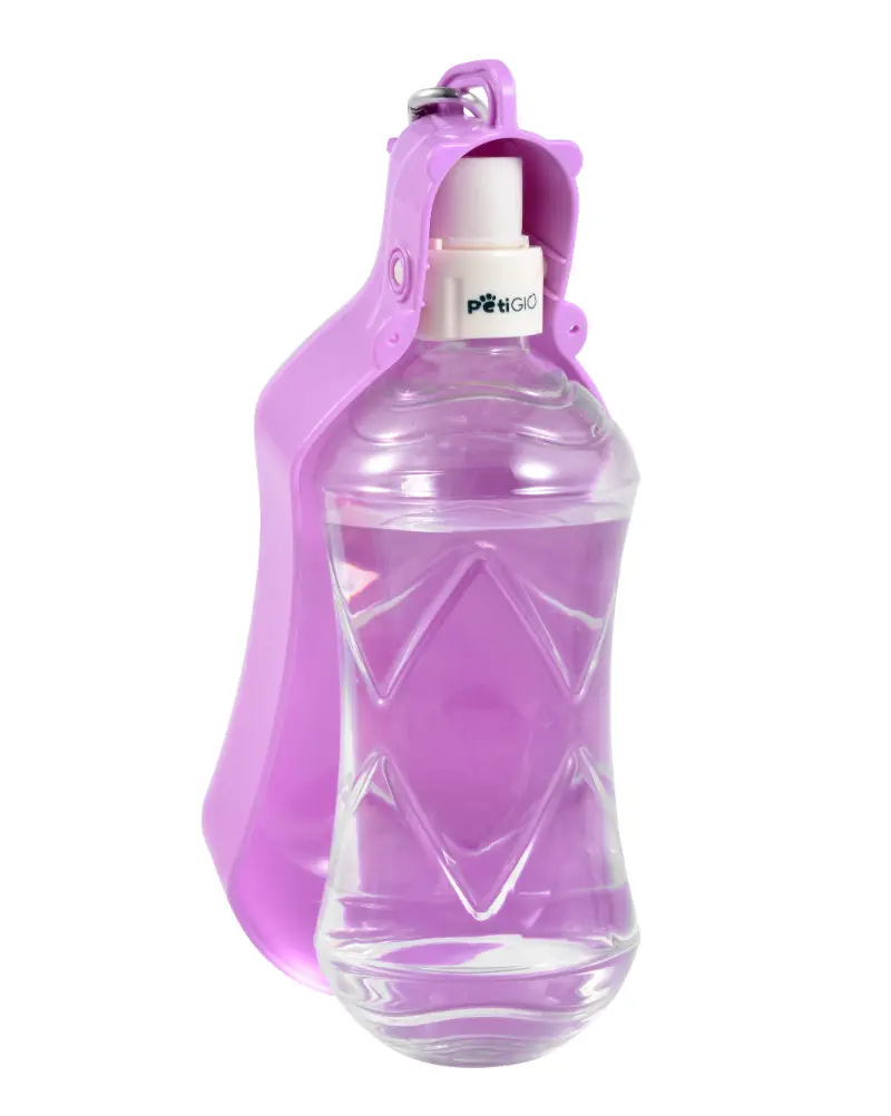 Fioletowa butelka na wodę dla psa wypełniona wodą. Butelka ma różową nakrętkę. Marka to Petigio.