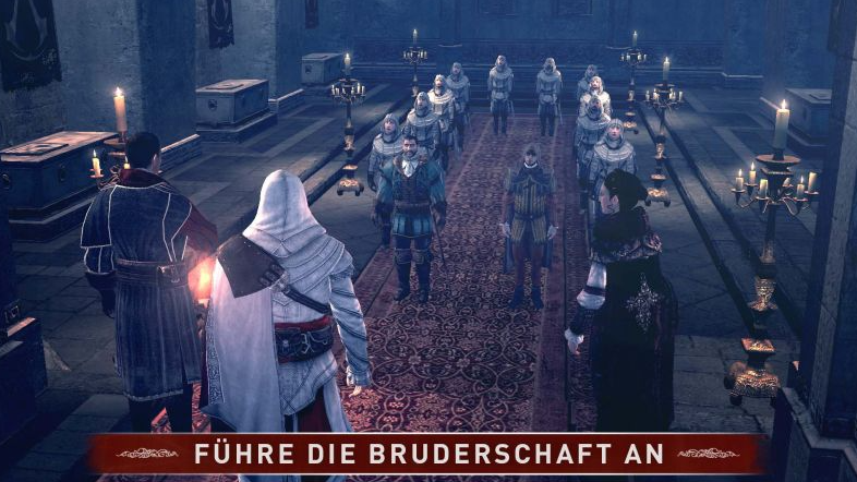 Eine Gruppe von Personen steht in einer dunklen Halle. Einige tragen weiße Roben, andere farbige Kleidung. Kerzen und Leuchter sind vorhanden.