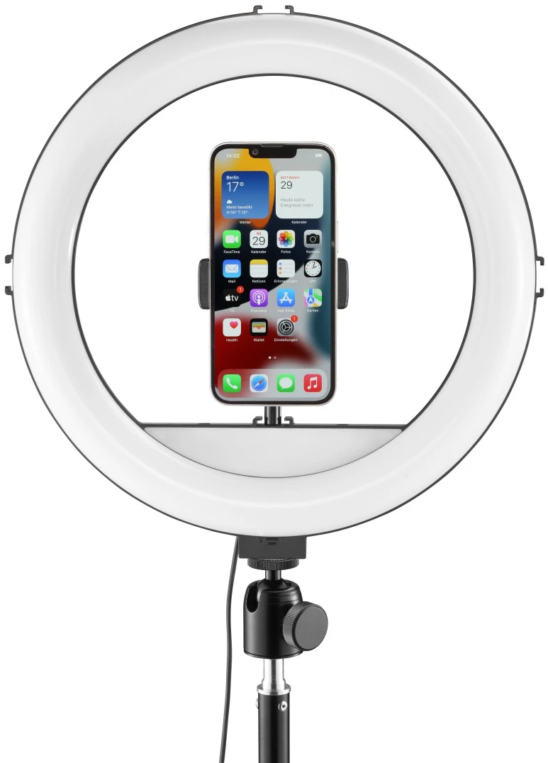 Ein Smartphone ist in einem Ringlicht montiert. Das Telefon zeigt Wetter, Datum und Uhrzeit an. Das Ringlicht steht auf einem schwarzen Ständer.