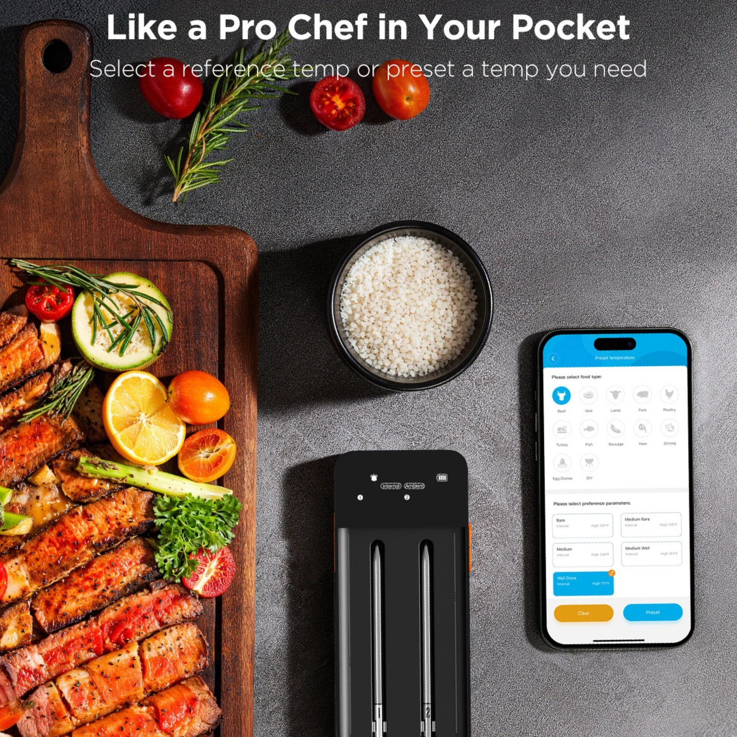 Un tagliere con carne grigliata, verdure e frutta. Un dispositivo nero con sonde e un telefono che mostra le opzioni di temperatura di cottura.