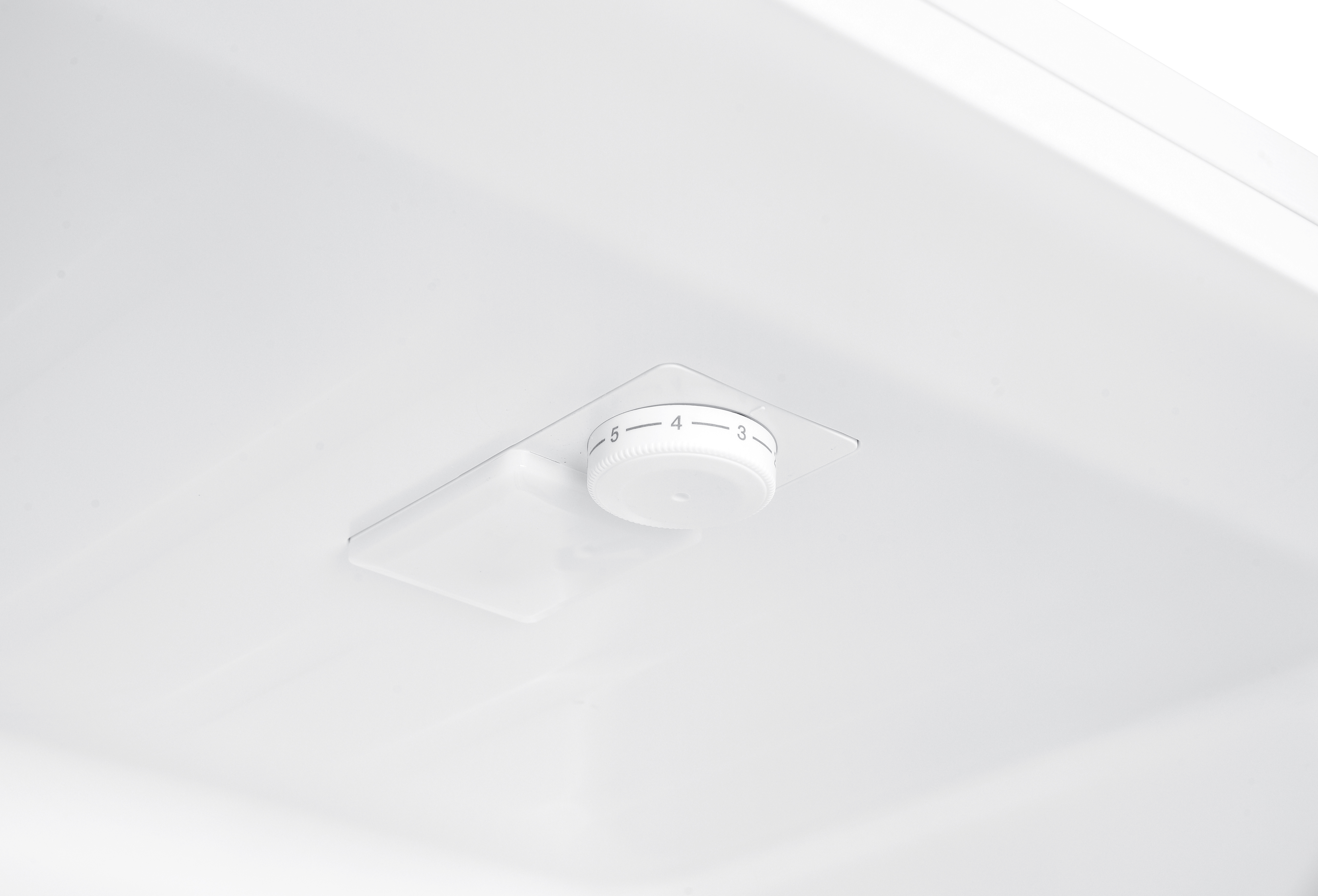 Ein weißer Kühlschrankinnenraum mit Temperaturregler, markiert mit 3, 4 und 5, ist an der Decke zu sehen.