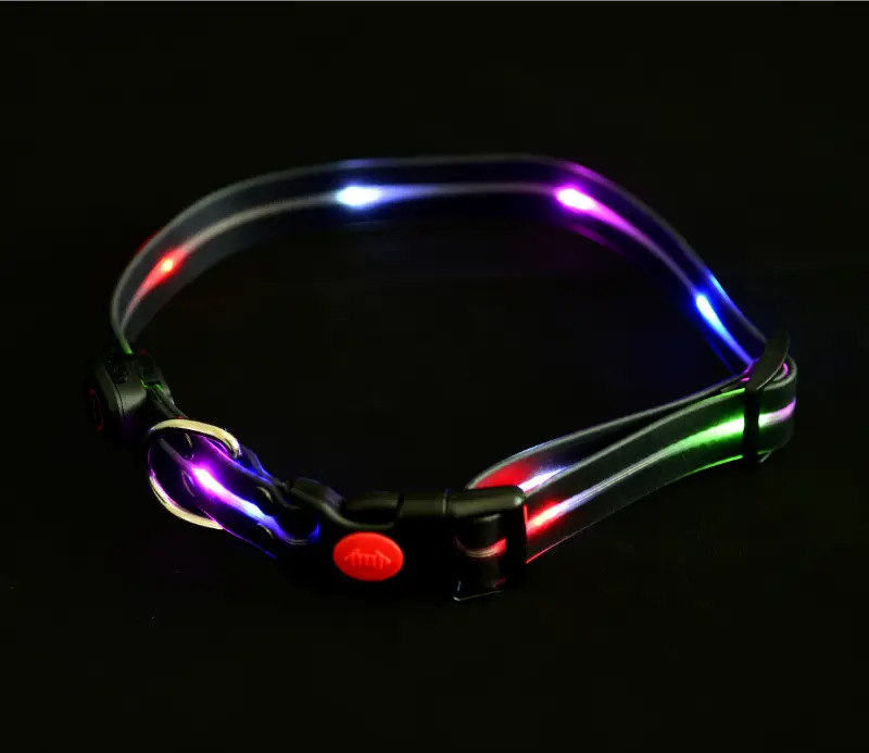 Świecąca obroża dla psa z wielokolorowymi światłami na czarnym tle. Ma czerwony przycisk i czarną klamrę.
