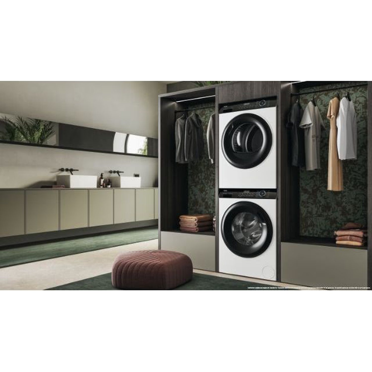 A modern laundry room with white washing machines, dark cabinets, and clothes hanging. A red ottoman is in the foreground.