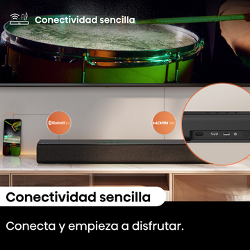 Una barra de sonido debajo de un televisor. Un teléfono muestra una imagen. Un tambor está en el fondo, con luz verde.