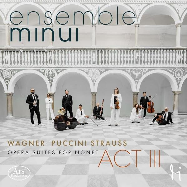Ensemble Minui: Musiker in einem weißen Saal. Zu den Instrumenten gehören Cello, Violine, Klarinette und andere. Text: 'Wagner, Puccini, Strauss'.