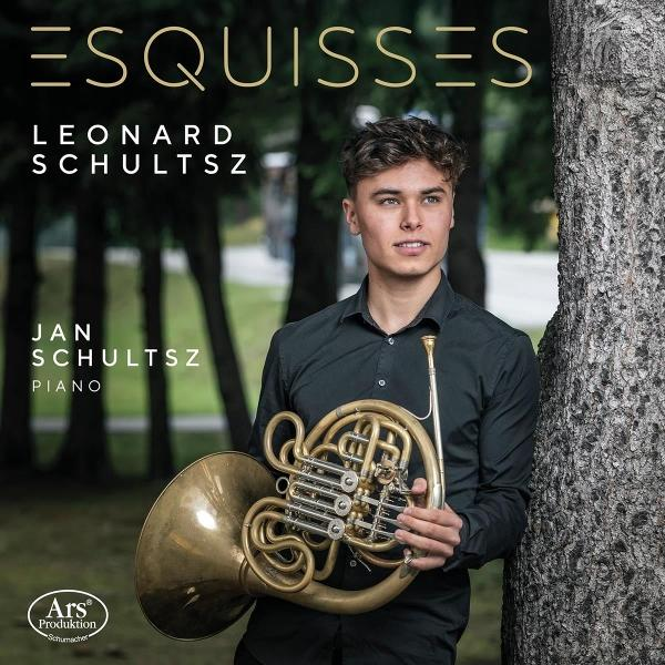 Ein junger Mann hält ein Waldhorn. Er lehnt an einem Baum. Text: ESQUISSES, Leonard Schultsz, Jan Schultsz, Piano.